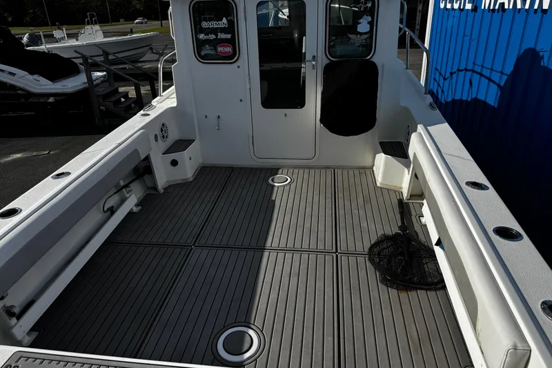 Slide: The Image of 2021 Parker 2320 Sport Cabin boat deck with fishing gear and seating. - 33