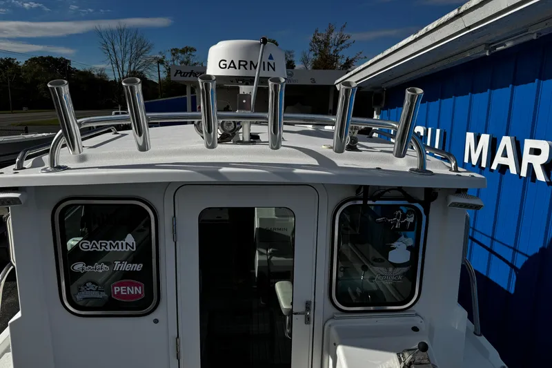 Slide: The Image of 2021 Parker 2320 Sport Cabin boat with Garmin equipment, docked near a blue building. - 35