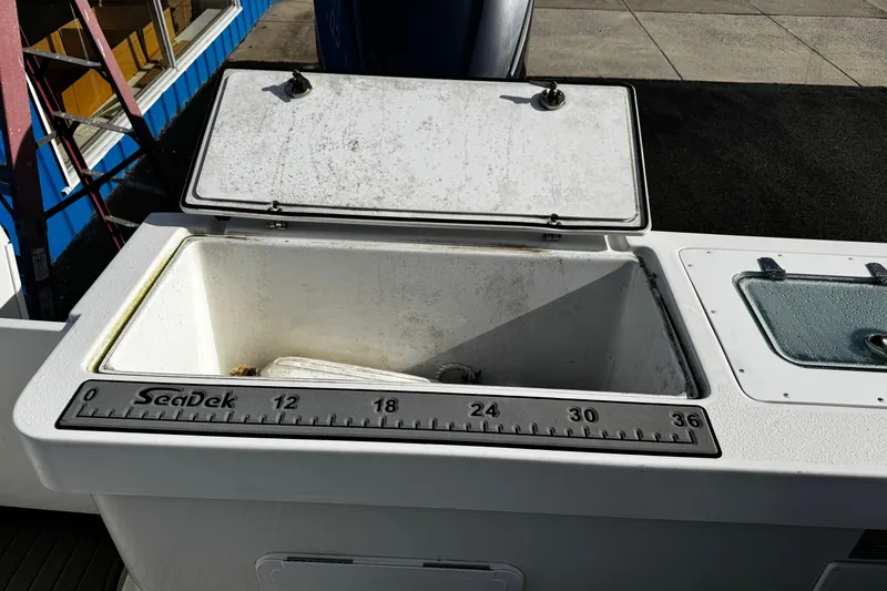 Slide: The Image of Open storage compartment on 2021 Parker 2320 Sport Cabin boat with SeaDek ruler. - 37