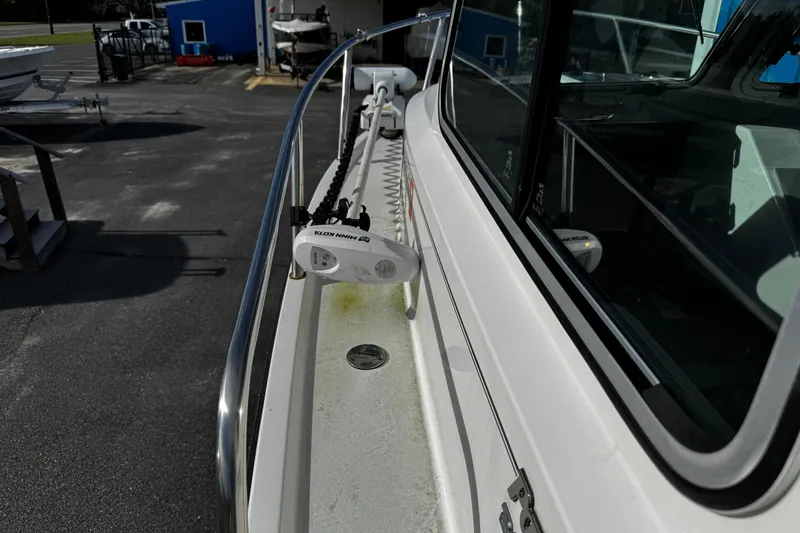 Slide: The Image of 2021 Parker 2320 Sport Cabin boat with Minn Kota motor, docked outdoors. - 4