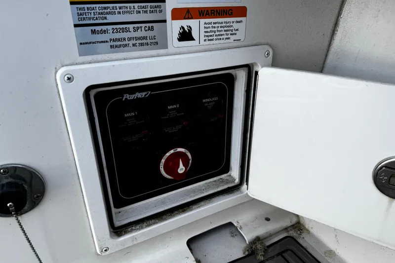 Slide: The Image of Control panel of a 2021 Parker 2320 Sport Cabin boat with safety warnings. - 42