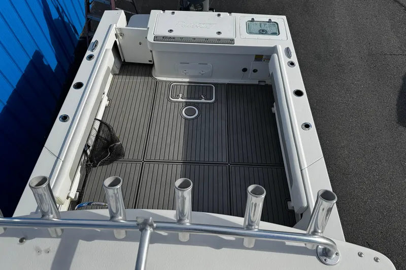 Slide: The Image of 2021 Parker 2320 Sport Cabin boat deck with rod holders and storage compartments. - 9