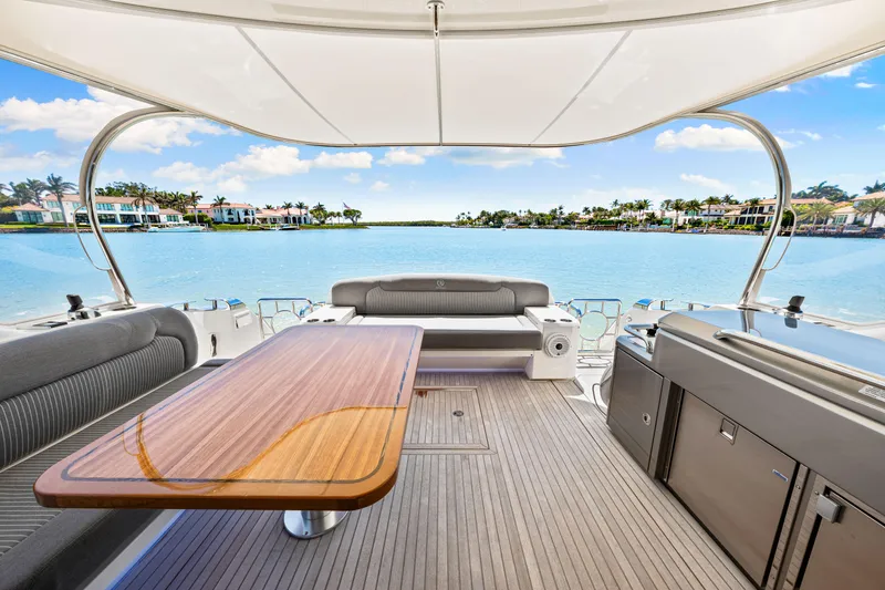Slide: The Image of 2022 Riviera 5400 Sport Yacht interior with elegant seating and scenic waterfront view. - 43