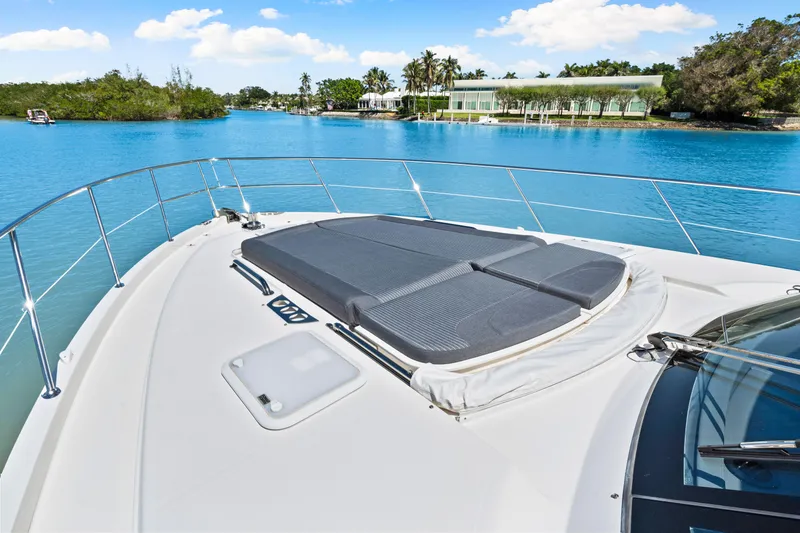 Slide: The Image of 2022 Riviera 5400 Sport Yacht on serene blue water, featuring spacious sunbathing deck. - 48