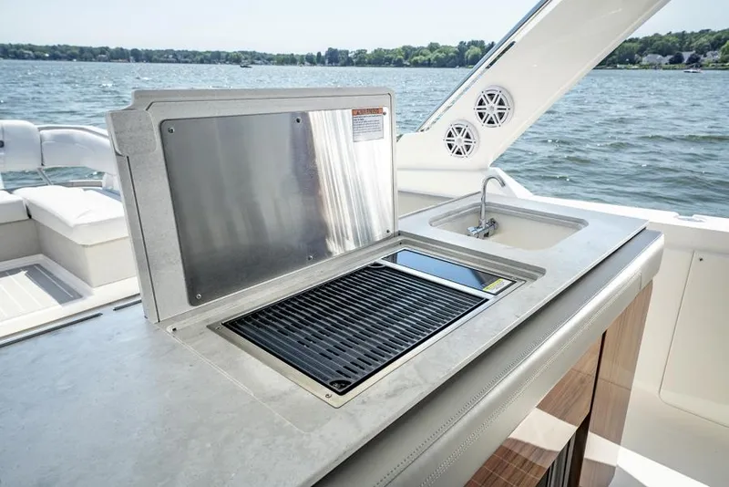 Slide: The Image of Manufacturer Provided Image: Outdoor kitchen on 2025 Tiara Yachts 43 LS, featuring grill and sink by the water. - 21
