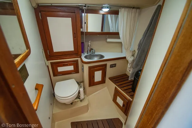 Slide: The Image of Bathroom interior of a 1984 Catalina 36 sailboat with wooden cabinetry and compact design. - 19