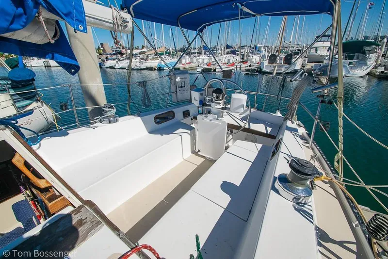 Slide: The Image of Cockpit of 1984 Catalina 36 sailboat docked in marina, featuring blue canopy and steering wheel. - 21