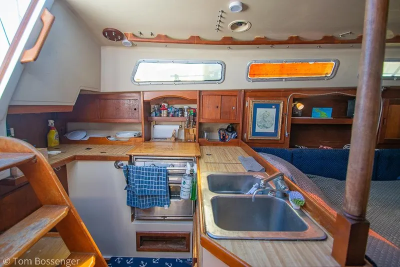Slide: The Image of Interior of a 1984 Catalina 36 sailboat featuring a compact kitchen and cozy seating area. - 6