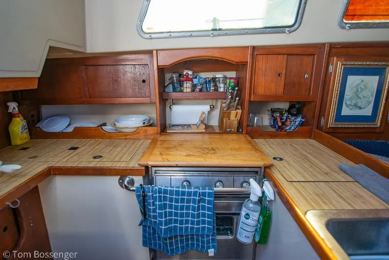 Slide: The Image of 1984 Catalina 36 yacht kitchen with wooden cabinets, stove, and utensils. - 8