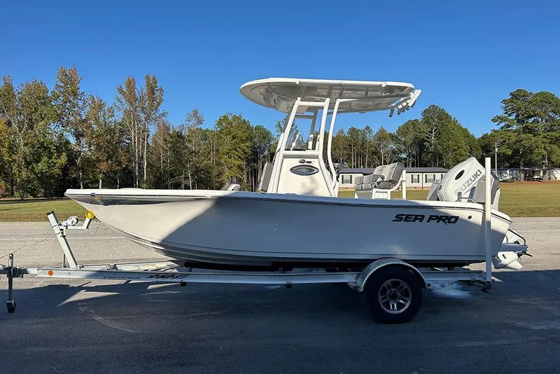 Slide: The Image of 2026 Sea Pro 202 Center Console boat on trailer, parked outdoors under clear blue sky. - 12