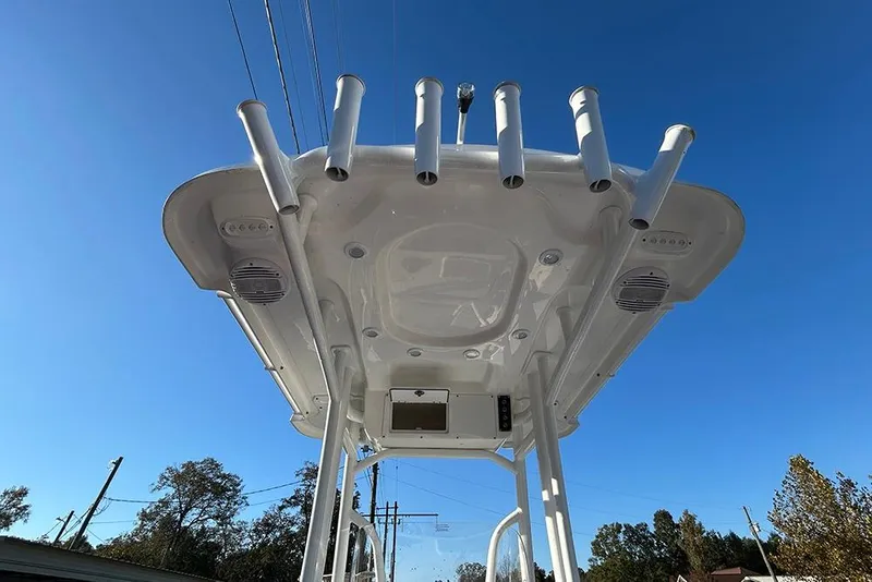 Slide: The Image of 2026 Sea Pro 202 Center Console boat with rod holders and speakers under a clear blue sky. - 52