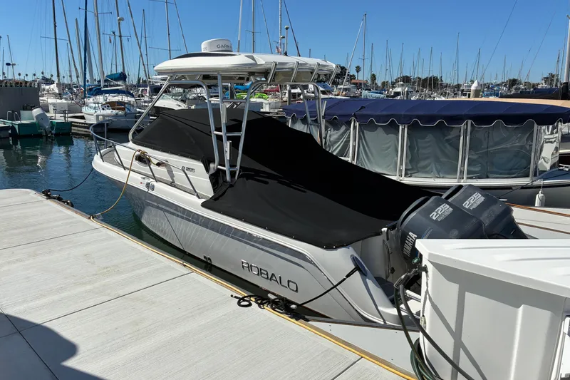 Slide: The Image of 2007 Robalo R265 Walkaround boat docked at marina with twin Yamaha engines. - 4