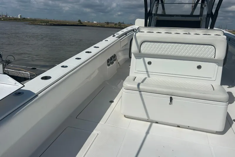 Slide: The Image of 2016 SeaHunter 39 Tournament boat interior with seating and rod holders, docked by the water. - 10