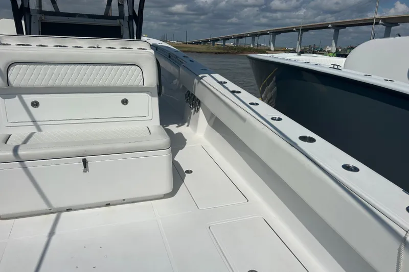 Slide: The Image of 2016 SeaHunter 39 Tournament boat interior with seating, docked near a bridge. - 11