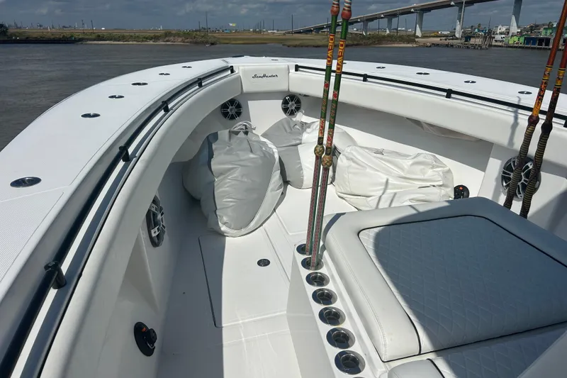Slide: The Image of 2016 SeaHunter 39 Tournament boat interior with fishing rods and seating, near a bridge. - 22