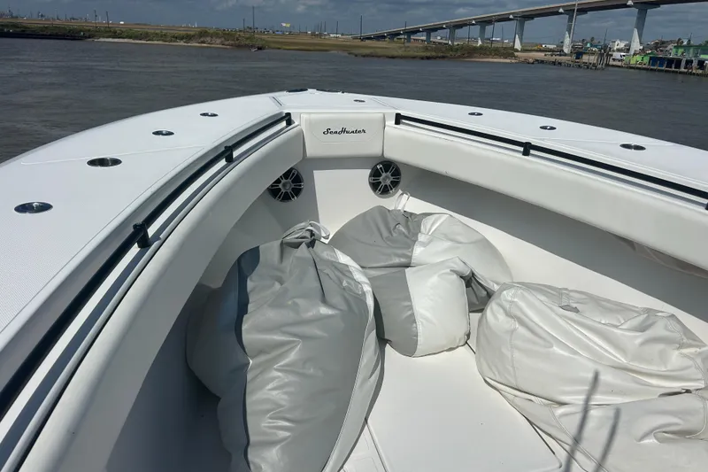 Slide: The Image of 2016 SeaHunter 39 Tournament boat with white deck and bean bags, near a bridge. - 27