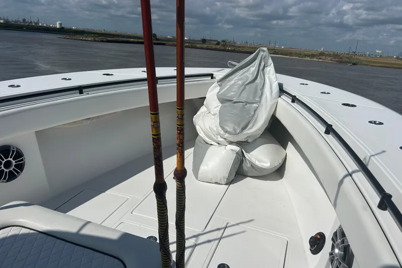 Slide: The Image of 2016 SeaHunter 39 Tournament boat deck with fishing rods and cushions, on a calm river. - 29