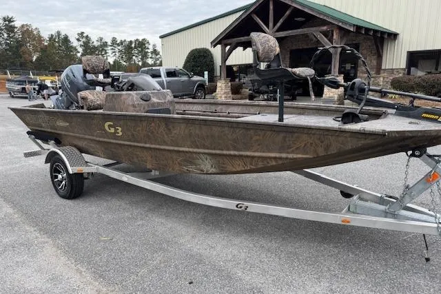 Slide: The Image of 2023 G3 Gator Tough 17 SC boat on trailer, camo design, parked outdoors. - 3