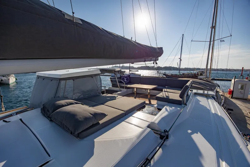 Slide: The Image of 2023 Fountaine Pajot Tanna 47 catamaran on water, showcasing deck and sails. - 6