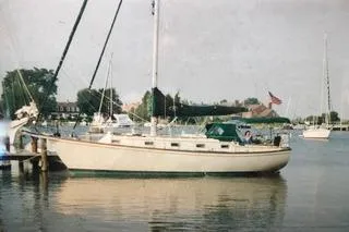 Slide: The Image of 1990 Island Packet 35 sailboat cruising on calm waters under a clear sky. - 2