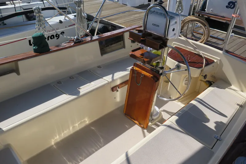 Slide: The Image of 1990 Island Packet 35 sailboat cockpit with steering wheel and wooden accents. - 21