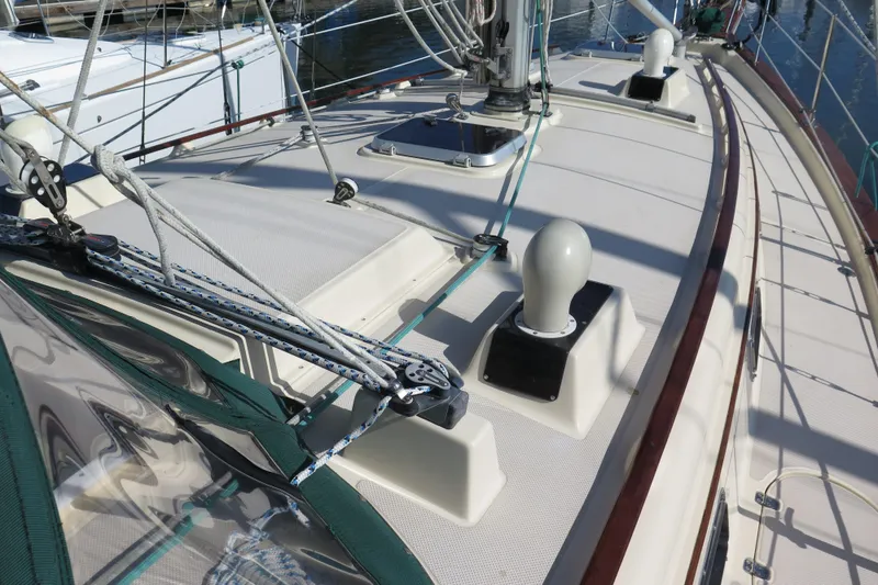 Slide: The Image of Books on sailboats, including Island Packet 35, displayed on a wooden table. - 32