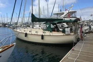 Slide: The Image of 1990 Island Packet 35 sailboat docked at marina, showcasing deck and rigging details. - 4