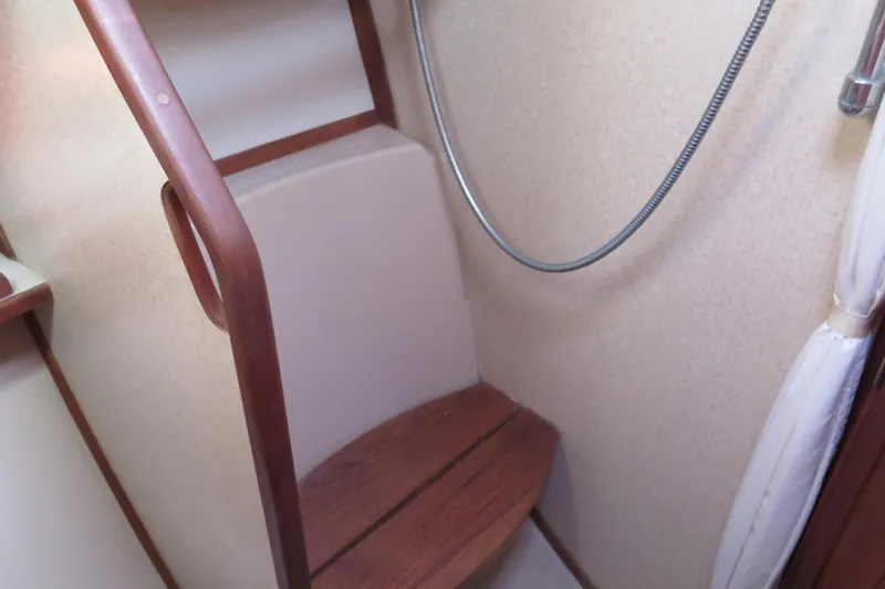 Slide: The Image of Cozy interior of 1990 Island Packet 35 sailboat with books, cushion, and kitchenette. - 44