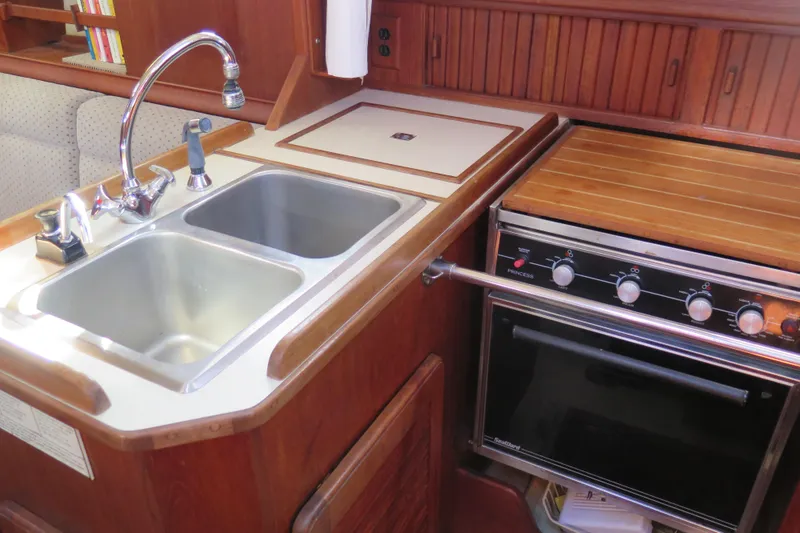 Slide: The Image of Interior of 1990 Island Packet 35 sailboat with wooden cabinetry and fire extinguisher. - 49