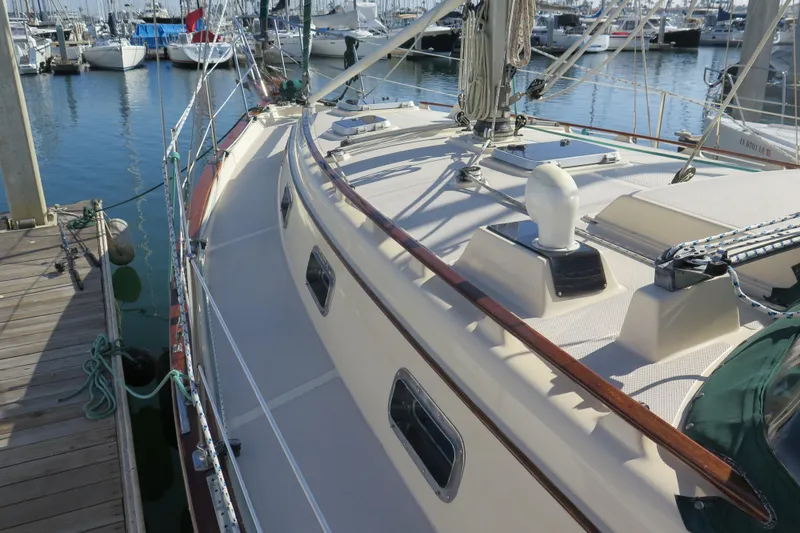 Slide: The Image of 1990 Island Packet 35 sailboat docked, showcasing deck and railing details. - 6