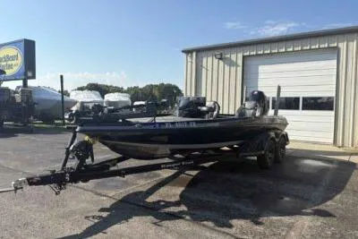 Slide: The Image of 2025 Ranger Z520R boat on trailer outside a garage under clear blue sky. - 2