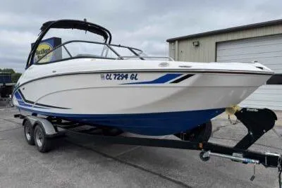 Slide: The Image of 2018 Yamaha Boats AR240 on trailer, white and blue design, parked outdoors. - 1