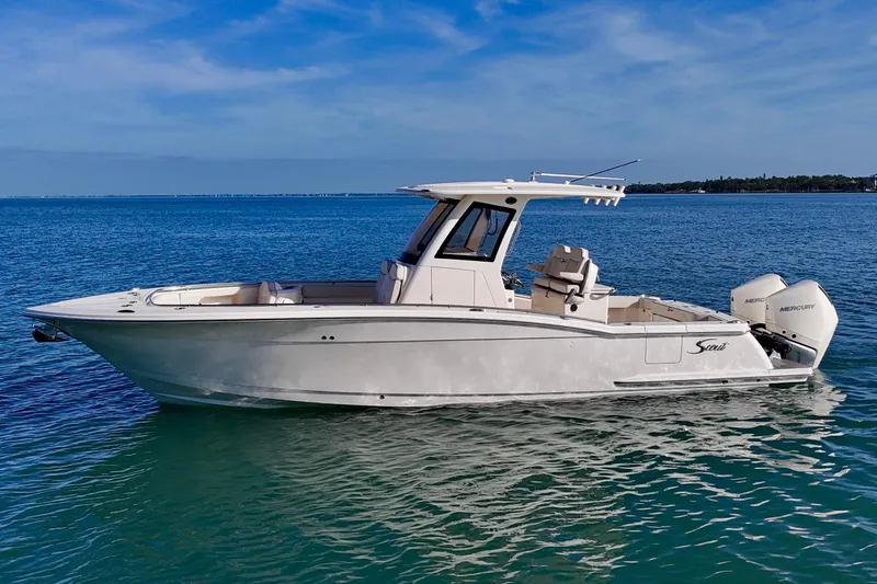 The Image of 2026 Scout 288 LXF boat on calm blue water, showcasing sleek design and twin Mercury engines. - 0