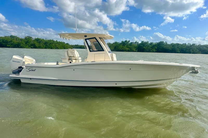 The Image of 2026 Scout 288 LXF boat on calm water under a blue sky. - 1