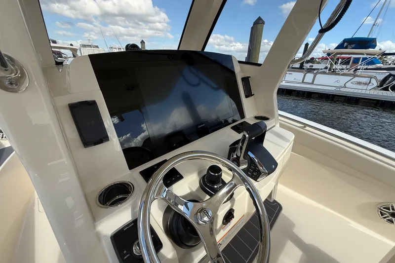 Slide: The Image of 2026 Scout 288 LXF boat dashboard with steering wheel and navigation display. - 11