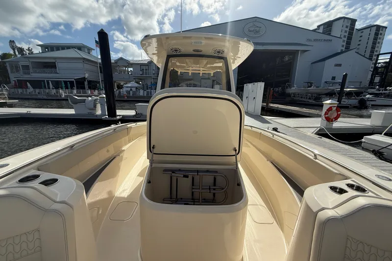 Slide: The Image of 2026 Scout 288 LXF boat docked at marina with open storage compartment. - 15