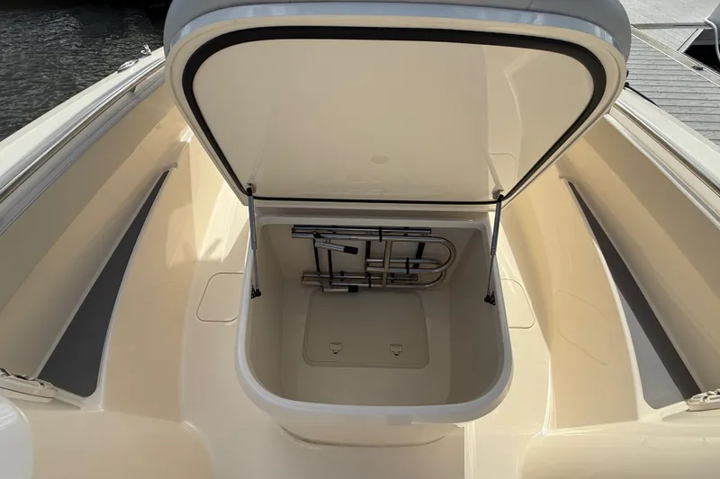 Slide: The Image of 2026 Scout 288 LXF boat storage compartment open, showcasing interior space. - 16