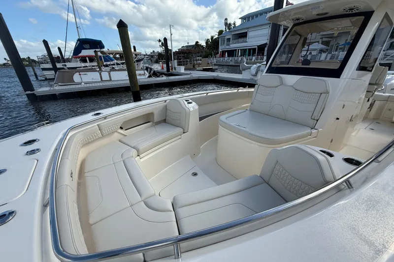 Slide: The Image of 2026 Scout 288 LXF boat with luxurious seating at a marina dock. - 19