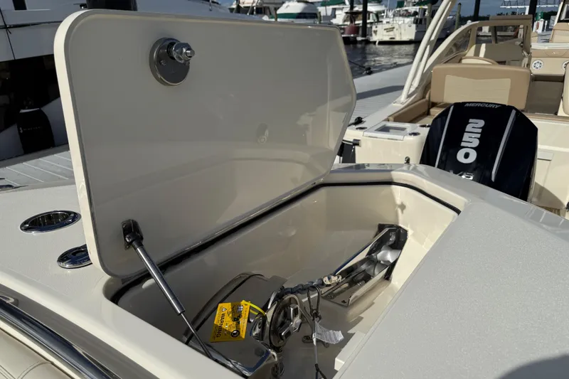 Slide: The Image of 2026 Scout 288 LXF boat with open storage compartment and Mercury 250 engine. - 21