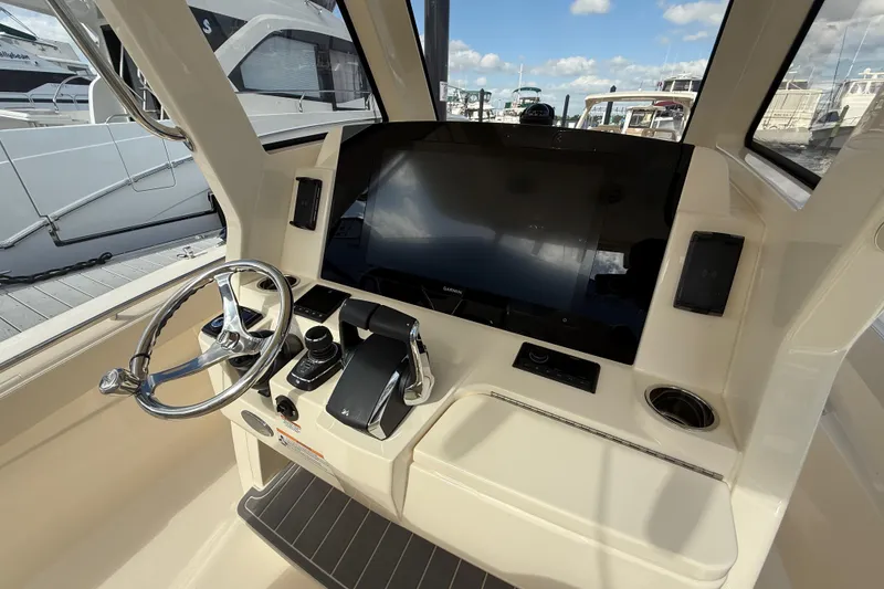 Slide: The Image of 2026 Scout 288 LXF boat helm with steering wheel and control panel. - 9