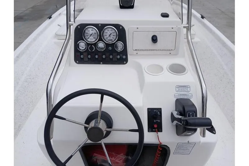 Slide: The Image of 2006 Mako 211 Inshore boat dashboard with steering wheel and control panel. - 10