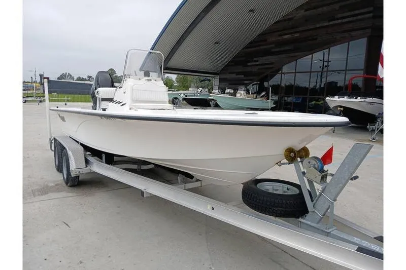 Slide: The Image of 2006 Mako 211 Inshore boat on trailer, parked outside a showroom. - 4