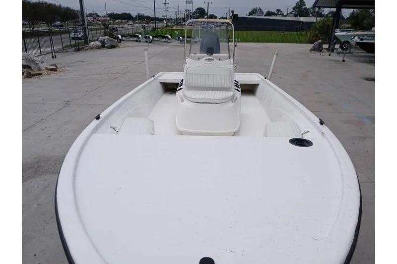 Slide: The Image of 2006 Mako 211 Inshore boat, white deck, center console, parked on concrete. - 5