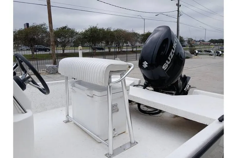 Slide: The Image of 2006 Mako 211 Inshore boat with Suzuki outboard motor, white seating, and console. - 6