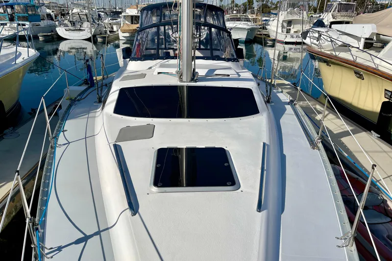 Slide: The Image of 1998 Hunter Passage 42 sailboat docked in a marina, surrounded by other boats. - 11