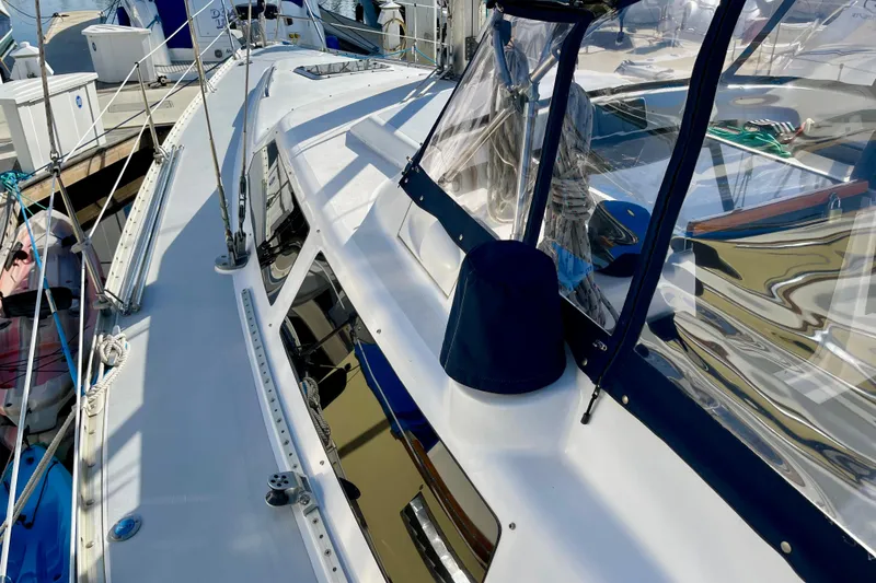 Slide: The Image of 1998 Hunter Passage 42 sailboat deck with clear canopy and marina background. - 18