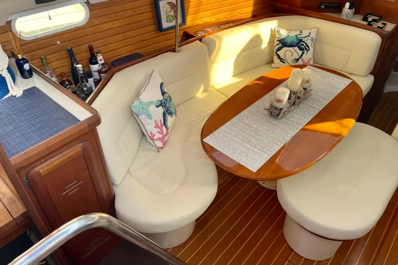 Slide: The Image of 1998 Hunter Passage 42 yacht interior with cozy seating, wooden table, and nautical decor. - 30