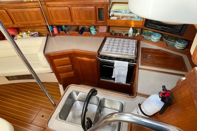 Slide: The Image of Interior of 1998 Hunter Passage 42 sailboat kitchen with wooden cabinetry and appliances. - 35
