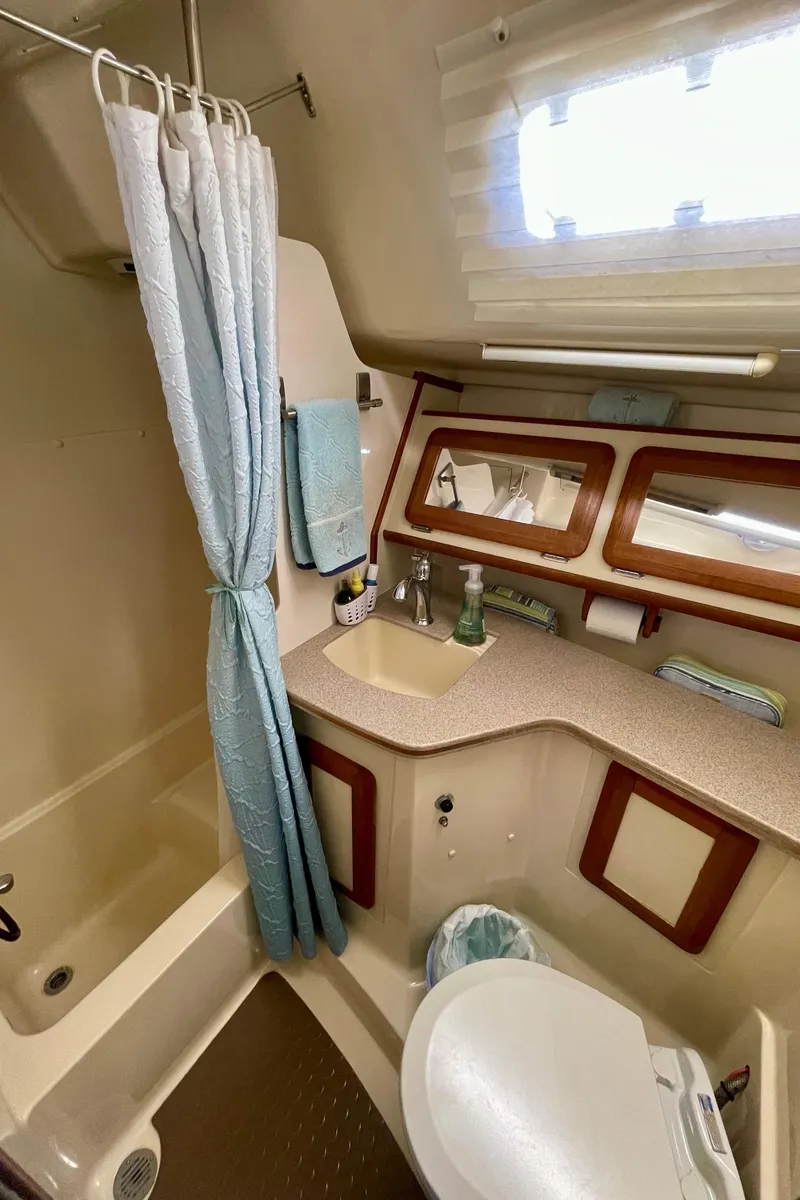 Slide: The Image of 1998 Hunter Passage 42 yacht bathroom with shower, sink, and toilet. - 49