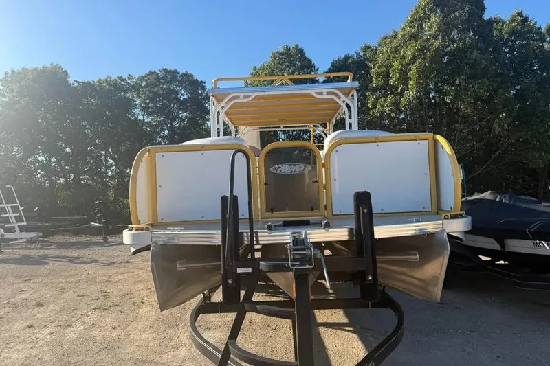 Slide: The Image of 2022 Aloha Pontoon Tropical 260 boat on trailer, surrounded by trees. - 2